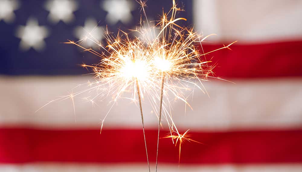 sparkler with American flag in background
