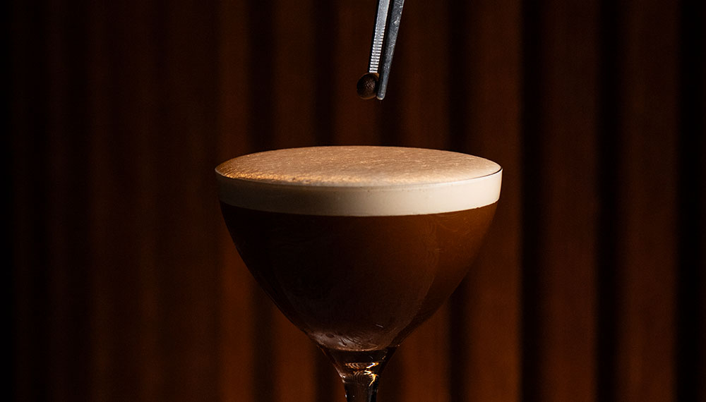 craft cocktail being poured from shaker