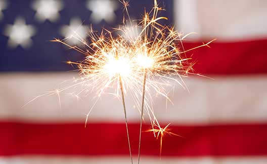 sparkler with American flag in background